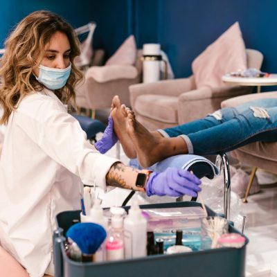 A beautician performs a pedicure on a client in a modern salon setting.