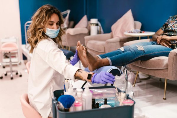 A beautician performs a pedicure on a client in a modern salon setting.