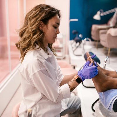 Woman giving pedicure treatment in a stylish modern salon. Beauty care focused.